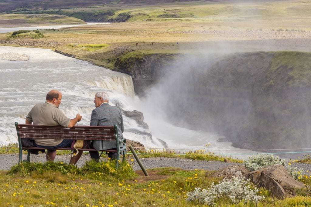 Men sitting at a bench in Iceland speaking Icelandic