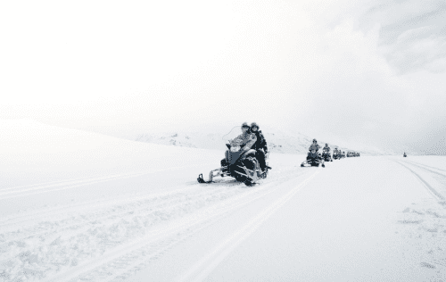 Snowmobiles dashing in whiteout